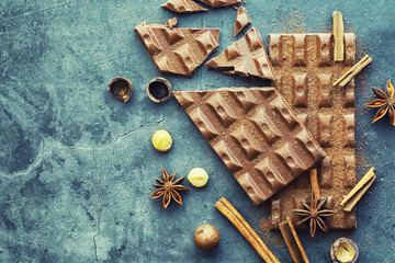 A bar of milk chocolate on the table. Chocolate with nuts and cinnamon.
