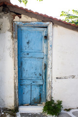 Antique blue painted front door on house in Greece. Traditional Greek architecture.