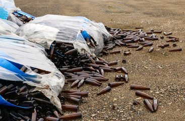 Obraz premium abandoned glass factory. packed bottles in pallets, broken bottles on asphalt, lots of loose bottles and garbage from production. devastation, separation, bankruptcy of enterprise.