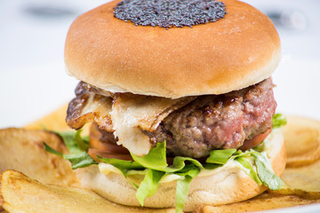 Gourmet hamburger with bacon and chips