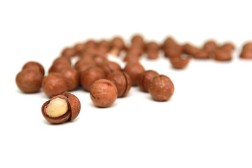 Shelled and unshelled macadamia nuts on white background.