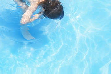 boy dives in swimming pool . boy swims in the pool. child learning to swim