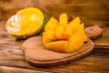 Cutting board with chopped mango fruit on a wooden table