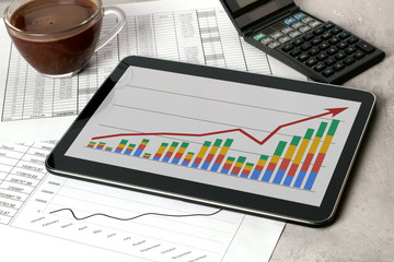 Workplace with tablet and stock charts. Accountant work table