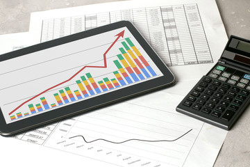 Workplace with tablet and stock charts. Accountant work table