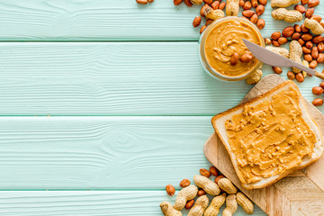 sandwiches with peanut butter for breakfast on mint green wooden background top view space for text