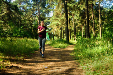 Obraz premium Woman jogging with garbage bag