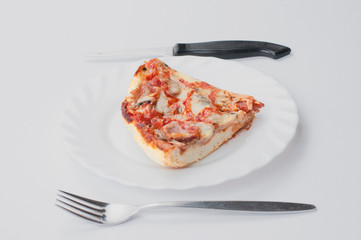 A delicious homemade pizza on a plate isolated on a white background. Pizza on a plate with a knife and a fork