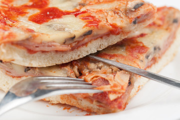 A delicious homemade pizza on a plate isolated on a white background. Pizza on a plate with a knife and a fork
