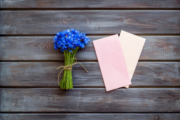 Bouquet of blue cornflowers, envelopes on wooden background top view mockup