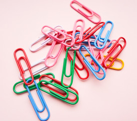 multicolored paper clips on a pink background. The concept is time to school.