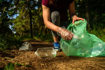 Woman collecting garbage in forest