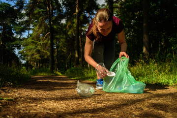 Woman collecting garbage in forest