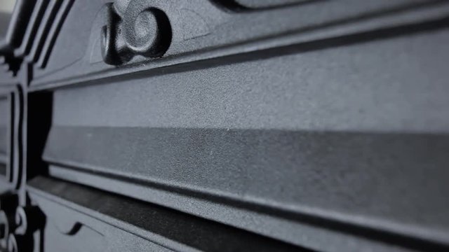 Inserting a letter inside a metallic wall-mounted mailbox. Everyday activities, getting obsolete quickly. Angled detail pov shot of the box hole.