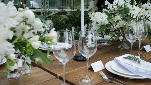 Beautiful Wooden Table Decoration for a Wedding Dinner in Rustic Style with Flower Bouquets and Candles