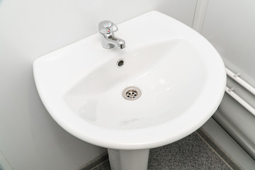 White clean sink with the crane in the bathroom