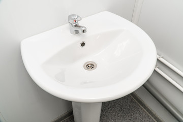 White clean sink with the crane in the bathroom