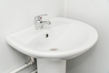 White clean sink with the crane in the bathroom