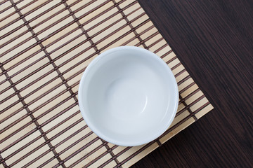 Empty clean bowl on a bamboo mat.Copy space
