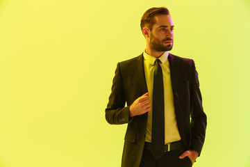 Image of masculine serious businessman in formal suit touching his jacket