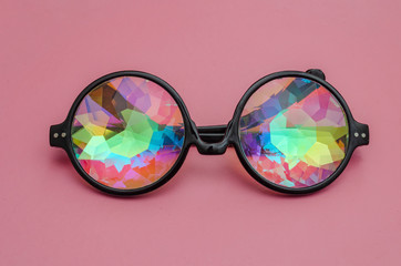 Designer glasses with kaleidoscope lenses on a pink background.