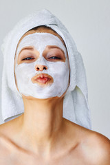 Beautiful woman with facial mask on her face. Skin care and treatment, spa, natural beauty and...