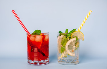 two glasses of lemonade with lime, lemon and mint leaves, peach and ice