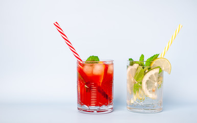 two glasses of lemonade with lime, lemon and mint leaves, peach and ice