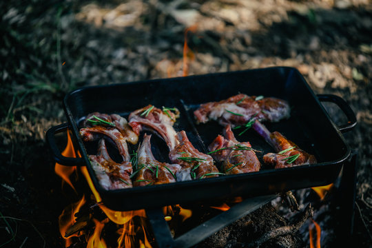 campfire red meat in pan, near the fire outdoors. bushcraft, adventure, travel, tourism and camping concept.