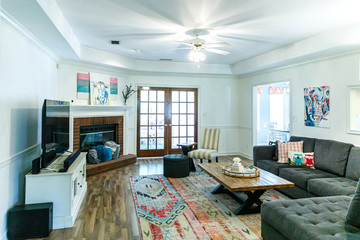 Bright living room in a house with neutral furniture , hardwood floors and a rug