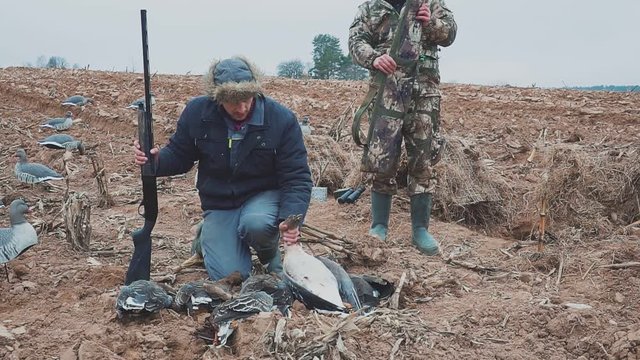 Happy hunter with a geese Extraction. Goose Hunter. hunting trophy