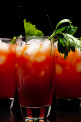 Cropped frame of Bloody Mary with ice cubes with celery isolated on black
