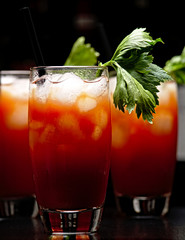 Cropped frame of Bloody Mary with ice cubes with celery in club on black