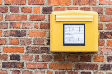 brick wall with german yellow mailbox deutsche post