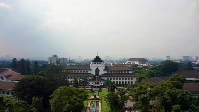 BANDUNG, Indonesia - July 03, 2019: Aerial view of Satay Building on misty morning in Bandung city, West Java, Indonesia. Shot in 4k resolution from a drone flying backwards