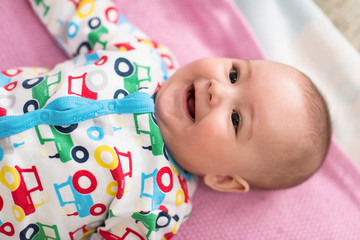 top view of newborn baby boy lying on colorful blankets