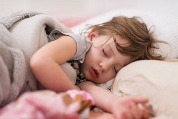 Fototapeta premium little gir sleeping in bed at home
