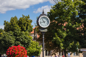 Fototapeta na wymiar Patterned street clock on the central square of a small town in Hungary