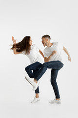Fototapeta na wymiar Beautiful young couple's portrait isolated on white studio background. Facial expression, human emotions, advertising concept. Copyspace. Woman and man jumping, dancing or running together.
