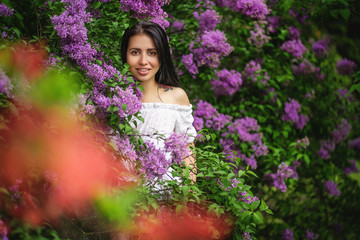 portrait of an authentic girl. Lilac bush on the background