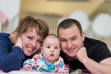 Obraz premium Portrait of young happy couple with their adorable baby boy