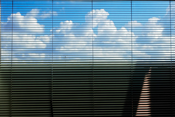 Sky and clouds behind Venetian curtain