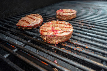 summer close up beef hamburger BBQ on a propane gas grill