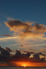 夕焼けでオレンジ色の雲と穏やかな海