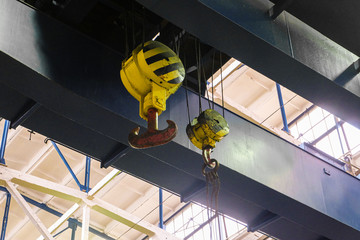 Overhead traveling crane with steel hooks in industrial engeenering plant shop