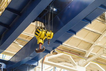 Overhead traveling crane with steel hooks in industrial engeenering plant shop