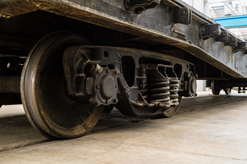 Railway wagon inside an industrial building. Steel wheels on rails close-up.