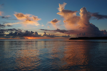 夕焼けでオレンジ色の雲と穏やかな海