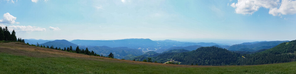 Obraz premium Panoramic view of the mountains under the blue cloudy sky in summer