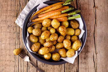 Roasted Vegetables in a Black Plate Wooden Background Vegetarian Dish Grilled Carrots and Potatoes Top View